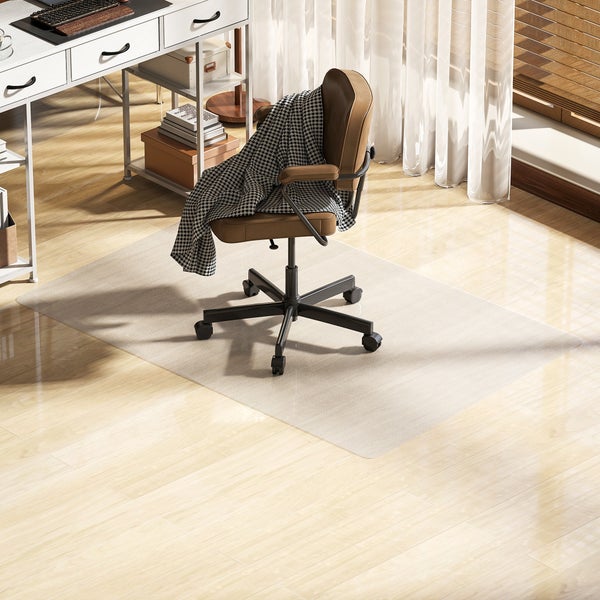 Rechteckige, halbtransparente Bodenschutzmatte für Hartböden in einem hellen Arbeitszimmer unter einem Bürostuhl.