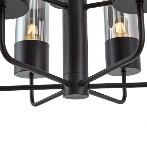 Detailaufnahme einer Deckenleuchte mit mehreren Armen und zylindrischen Glasschirmen