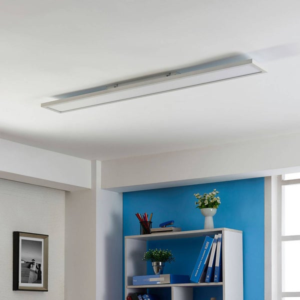 Rechteckiges LED-Panel an der Decke eines hellen, modern eingerichteten Raumes mit Regal und Wandbild.