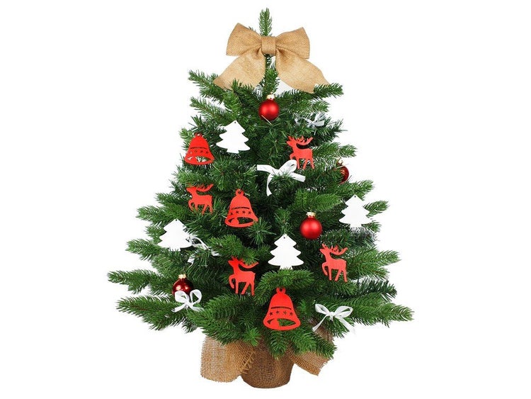 Künstlicher Weihnachtsbaum mit Jute-Topf, dekoriert mit Weihnachtskugeln und Anhängern in Form von Tannenbäumen, Rentieren und Glocken.