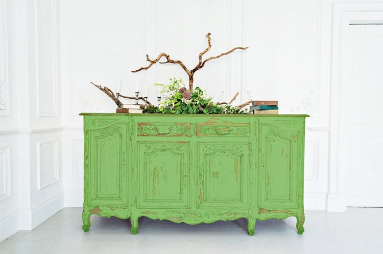 Antike grüne Kommode mit Schubladen, Türen und dekorativen Elementen im Wohnzimmer