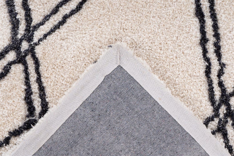 Nahaufnahme eines Hochflor-Teppichs mit Blick auf die gewebte Rückseite und die verstärkte Eckkante.