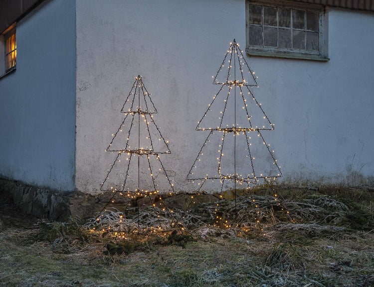 Zwei beleuchtete Weihnachtsbaumdekorationen im Außenbereich