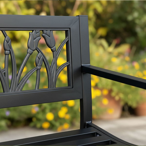 Nahaufnahme einer Gartenbank aus Metall mit dekorativem Tulpen-Motiv im Rückenteil.