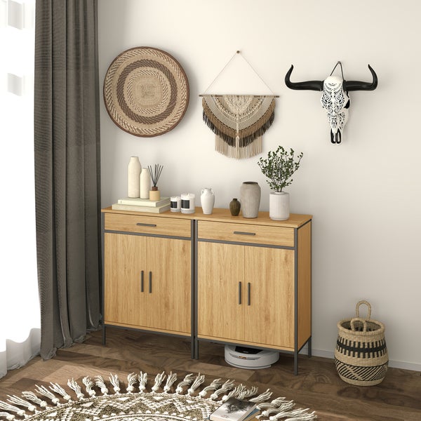 Sideboard in Holzoptik mit Metallgestell, dekoriert mit Vasen und Kerzen sowie Boho-Wanddekoration wie Makramee und einem Flechteller.