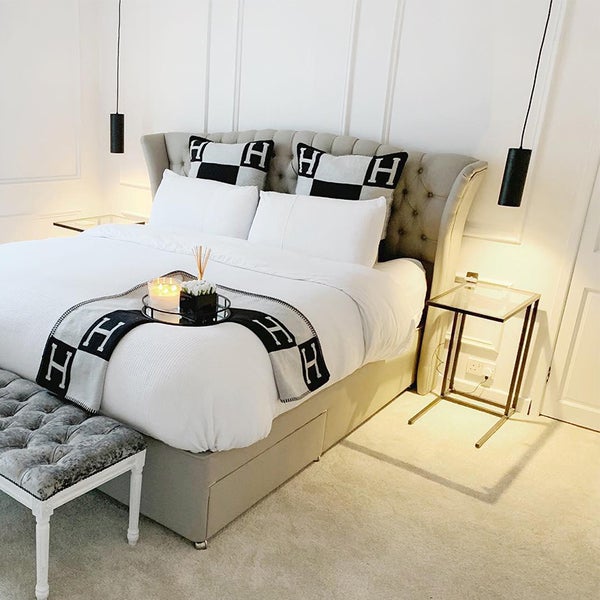 Helles Schlafzimmer mit Bett, Nachttischen und dekorativen Elementen