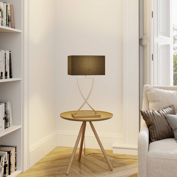 Detailaufnahme des goldenen Lampenfußes auf einem Tisch