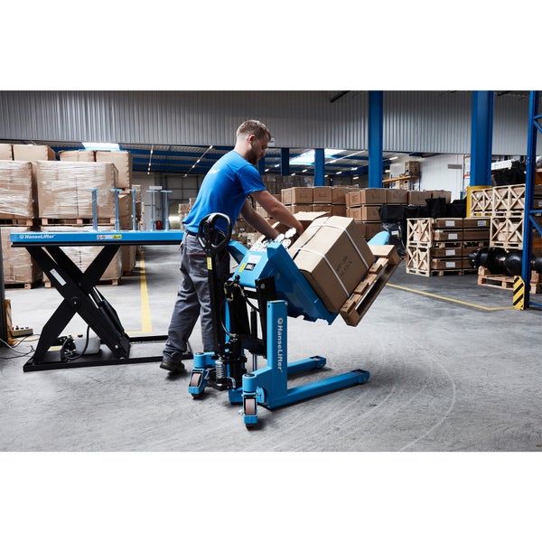 Ein Mann arbeitet ergonomisch in einem gut organisierten Lagerhaus mit einem blauen HanseLifter Palettenkipper und einem schwarzen Scherenhubtisch.
