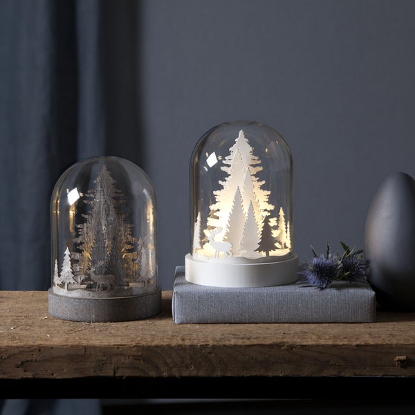 Zwei dekorative Weihnachtskuppeln mit Baum Motiven auf einem Holztisch