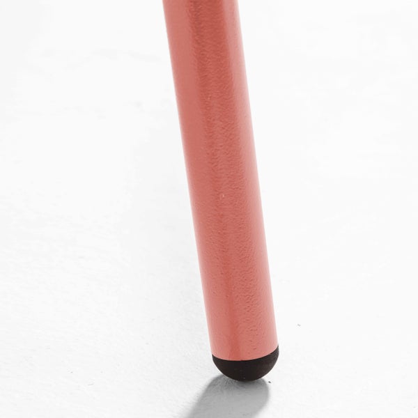 Detailaufnahme eines lachsfarbenen Stuhlbeins aus Metall mit schwarzem Bodengleiter.