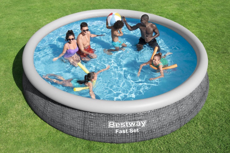 Bestway Fast Set Pool in Rattanoptik mit aufblasbarem Ring im Garten, in dem eine Familie mit Kindern spielt.