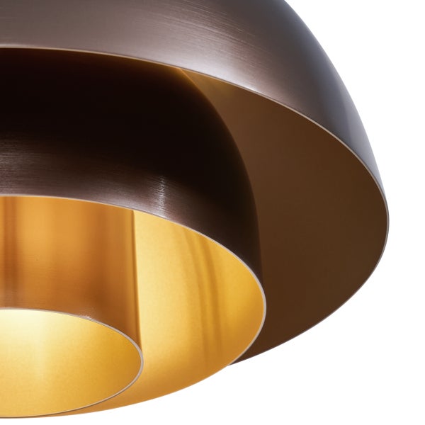 Detailaufnahme einer Pendelleuchte mit geschwungenen, metallischen Lampenschirmen