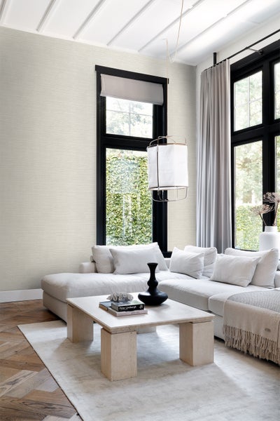 Wohnzimmer mit beiger Tapete, Sofa und Tisch