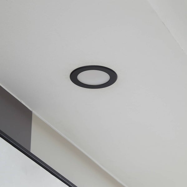 Runder LED-Einbaustrahler mit schwarzem Rahmen, flach in eine weiße Decke montiert.