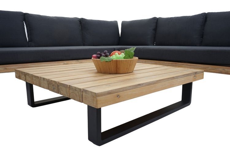 Lounge-Couchtisch mit Holzlattenplatte und dunklem Metallgestell vor einem L-förmigen Outdoorsofa mit grauen Polstern.