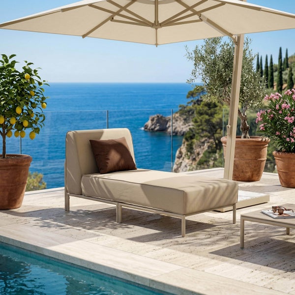 Beige Gartenliege mit braunem Kissen unter einem Sonnenschirm auf einer Terrasse am Pool mit Meerblick.