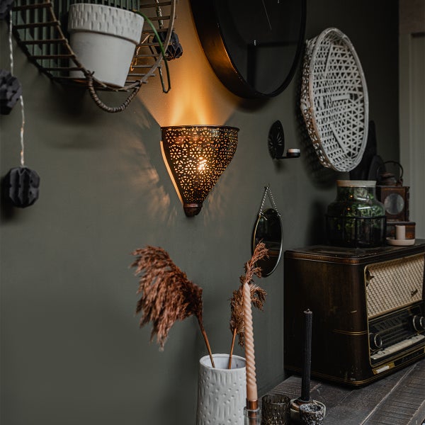 Wand mit Dekorationen wie Wandleuchte, Spiegel, Uhr und Radio