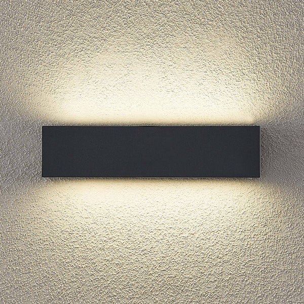 Rechteckige schwarze Wandleuchte mit Lichtaustritt nach oben und unten an einer strukturierten Wand.