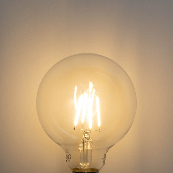 LED Filament Globelampe aus klarem Glas mit leuchtenden Filamenten und warmem Licht.