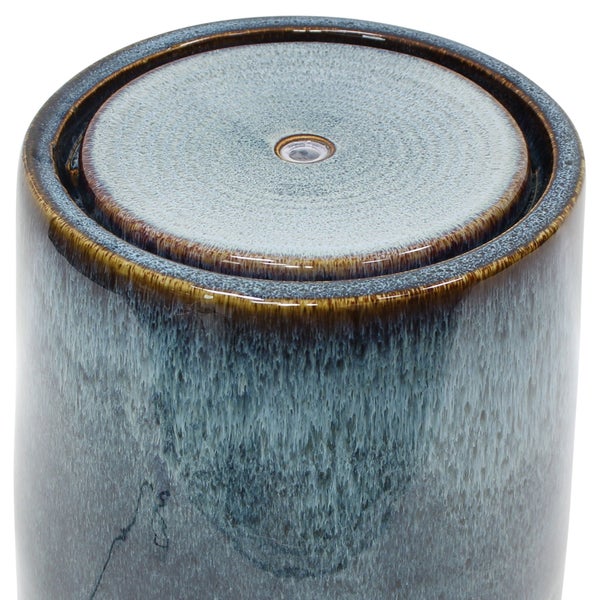 Zylinderförmiger Brunnen aus blau-braun glasierter Keramik mit strukturierter Oberfläche.