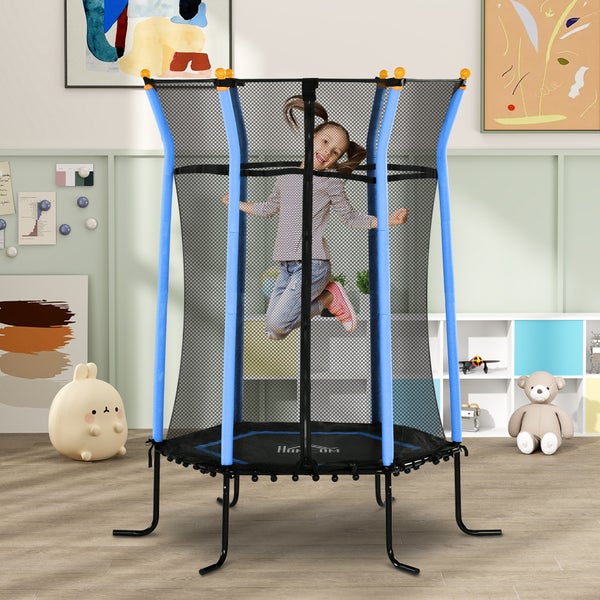 Kind auf einem Kindertrampolin mit Sicherheitsnetz in einem Zimmer