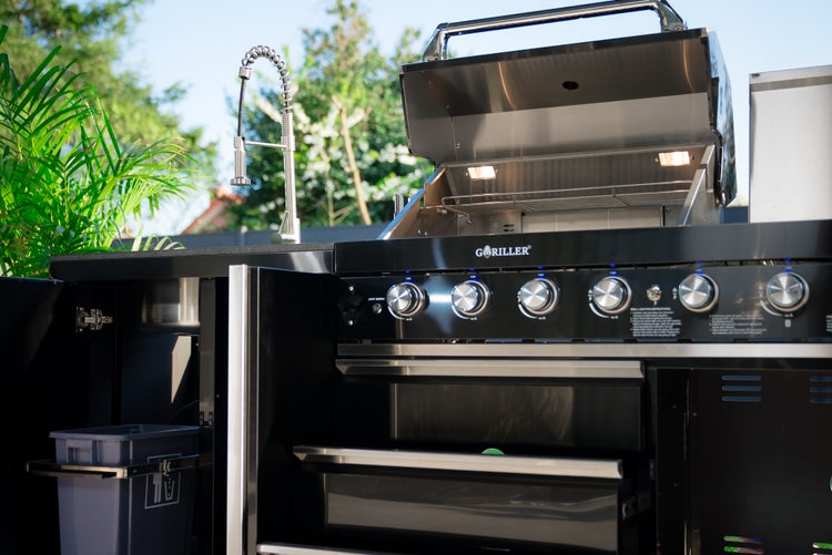 Goriller Außenküche mit Gasgrill, Edelstahl-Armatur, Spülbecken und integriertem Stauraum. Der Grill hat eine offene Haube mit Innenbeleuchtung.