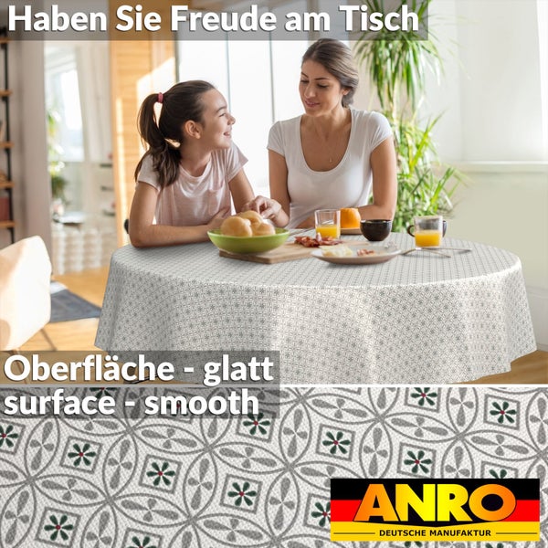 Rundes, abwaschbares Tischtuch mit glatter Oberfläche und geometrischem Ornament-Muster in einer hellen Wohnküche. ANRO Logo.