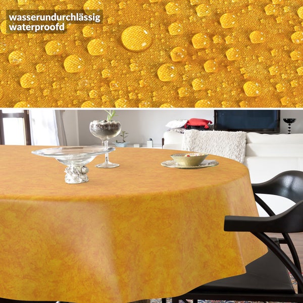 Gelbe, runde, wasserundurchlässige Tischdecke mit marmoriertem Muster. Detailansicht zeigt Wassertropfen auf dem Stoff.