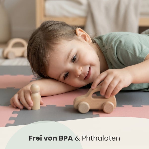 Ein Kind spielt mit einem Holzauto auf einer hellen Puzzle-Spielmatte. Das Produkt ist frei von Bisphenol A und Phthalaten.