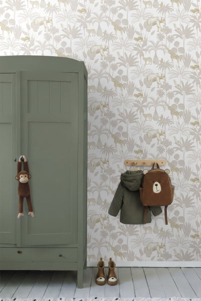 Vliestapete mit Safari-Motiv aus Elefanten, Giraffen und Palmen in einem Kinderzimmer neben einem grünen Holzschrank.