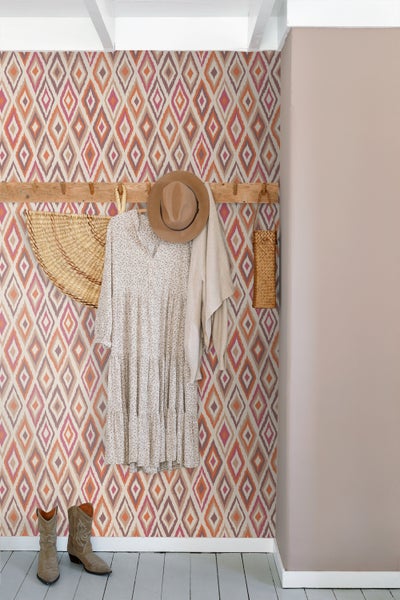 Dekoratives Zimmer mit gemusterter Tapete und Kleiderhakenleiste