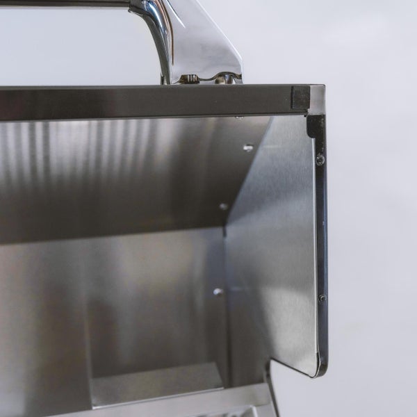 Detailaufnahme eines Grills aus Edelstahl mit poliertem Griff und Innengehäuse.