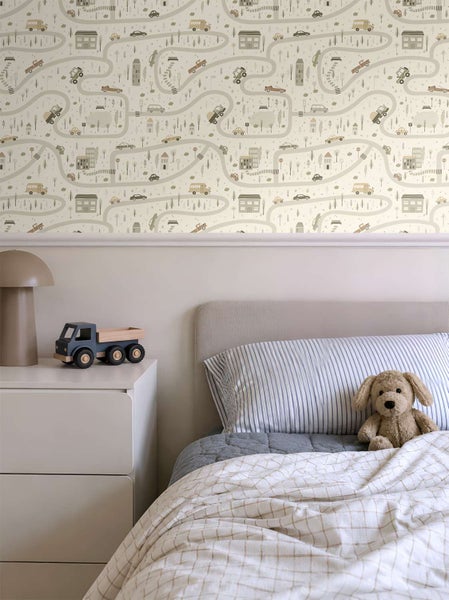 Kinderzimmer mit Tapete mit Stadtmotiv und Straßenmuster sowie einem Bett und einer Kommode.