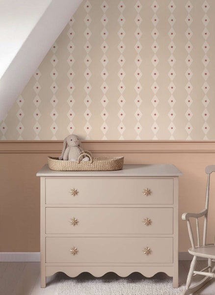 Kindertapete mit Rautenmuster an einer Wand über einer Kommode in einem Kinderzimmer