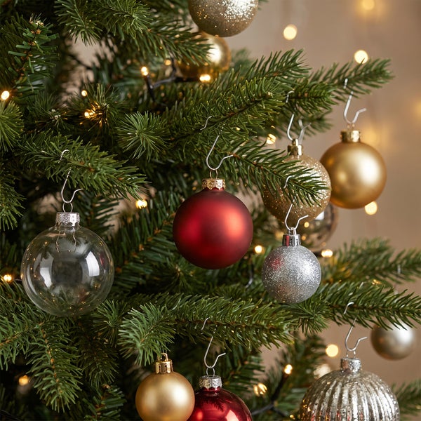 Weihnachtsbaum mit verschiedenen Weihnachtskugeln in verschiedenen Oberflächen und Formen dekoriert.