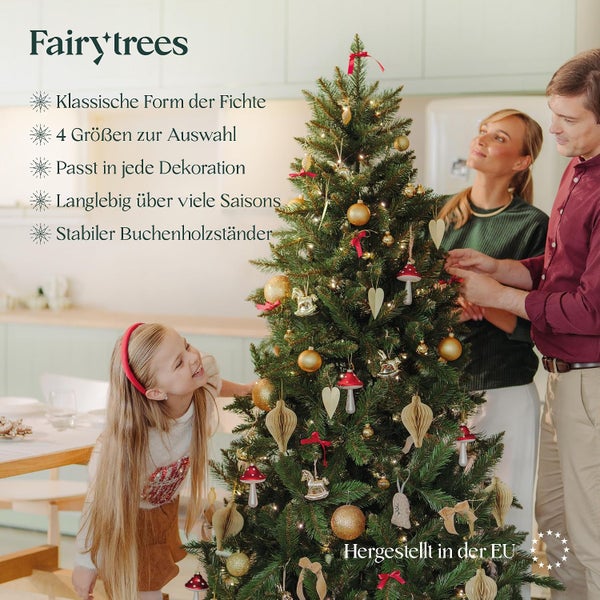Familie schmückt gemeinsam einen kuenstlichen Fairytrees Weihnachtsbaum in klassischer Fichtenform mit Buchenholzstaender in einem Wohnraum.