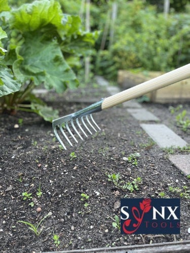 Gartenrechen aus Metall mit Holzgriff im Einsatz im Beet. Sonx Tools Logo.