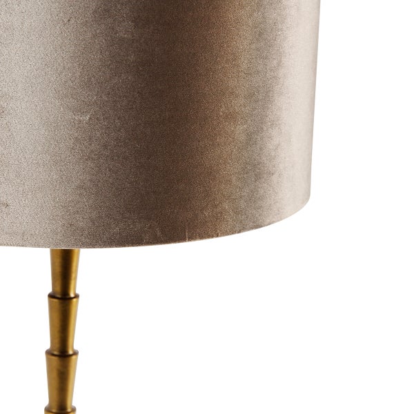 Nahaufnahme einer Stehlampe mit Stoffschirm und Metallfuß.