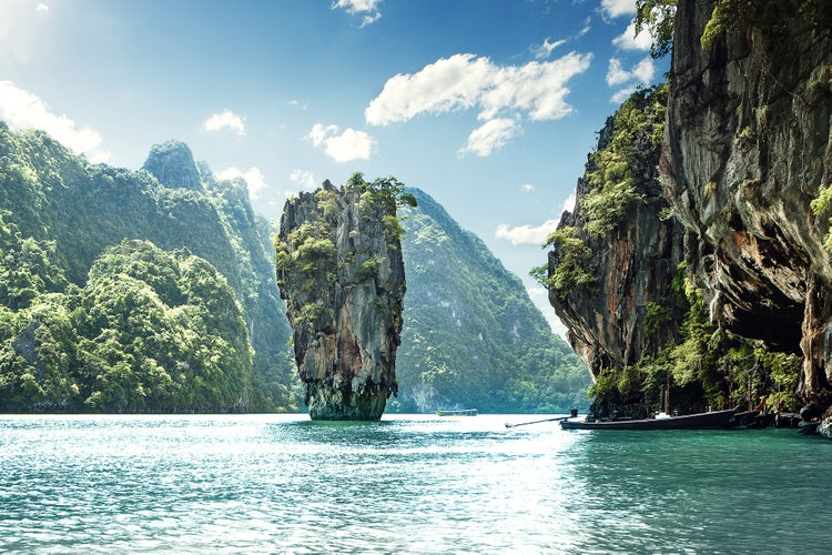 Landschaftstapete mit Ko Tapu Felsen in der Bucht von Phang Nga in Thailand mit umgebenden Kalksteinfelsen und einem traditionellen Longtail Boot.