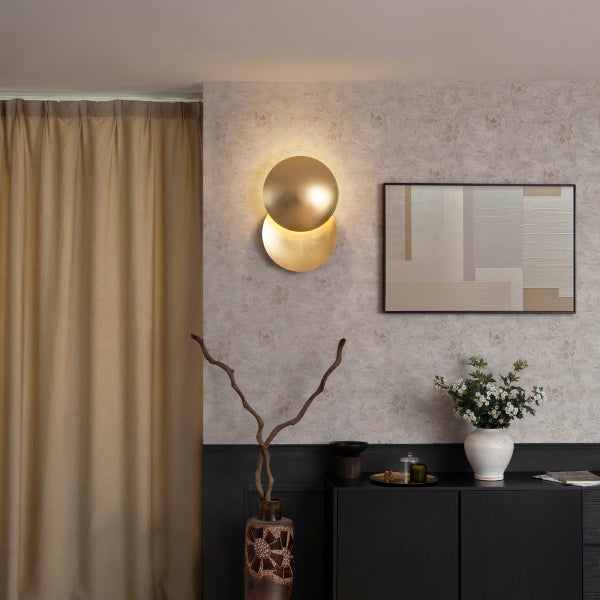 Wandleuchte mit zwei runden Elementen in einem Raum mit Vorhang, Bild und Kommode