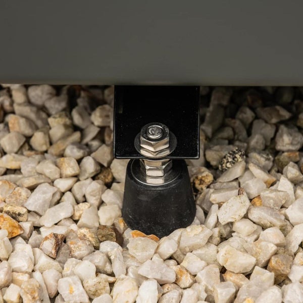 Detailaufnahme eines höhenverstellbaren Möbelfußes auf Kies