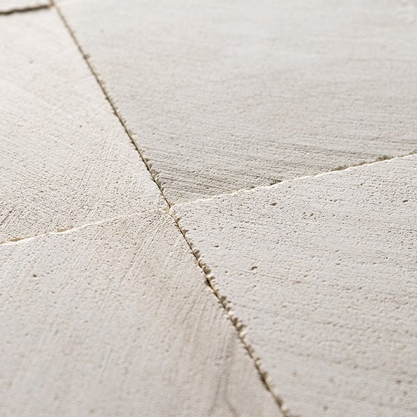 Nahaufnahme von quadratischen Natursteinplatten mit strukturierter Oberfläche und sichtbaren Fugen für den Außenbereich.