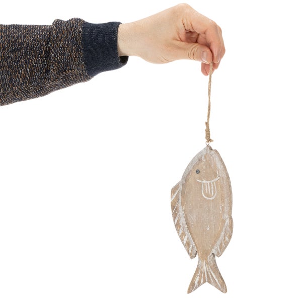 Eine Hand hält eine dekorative Fischfigur aus Holz an einer Kordel.