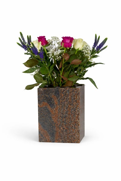 Quadratische Grabvase aus Granit mit einem Blumenstrauß aus Rosen Schleierkraut und Ehrenpreis