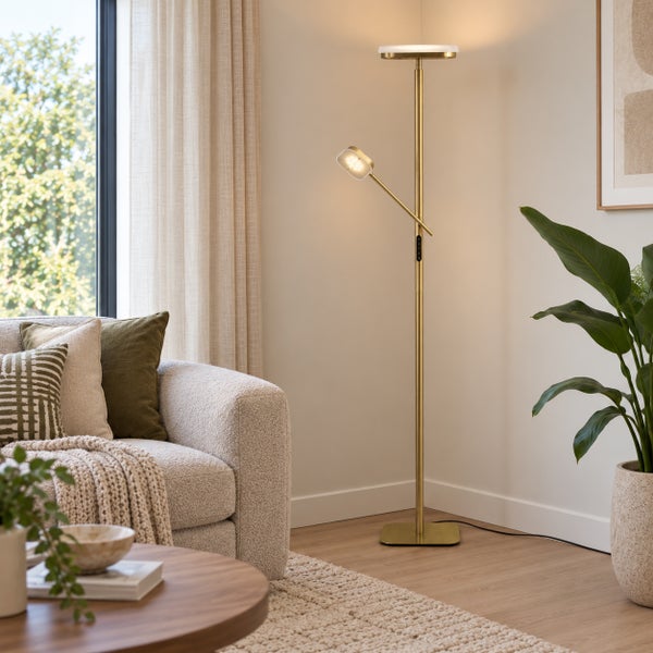 Moderne Stehleuchte aus Metall in Wohnzimmer mit Deckenfluter und Leselicht neben einer Couch.
