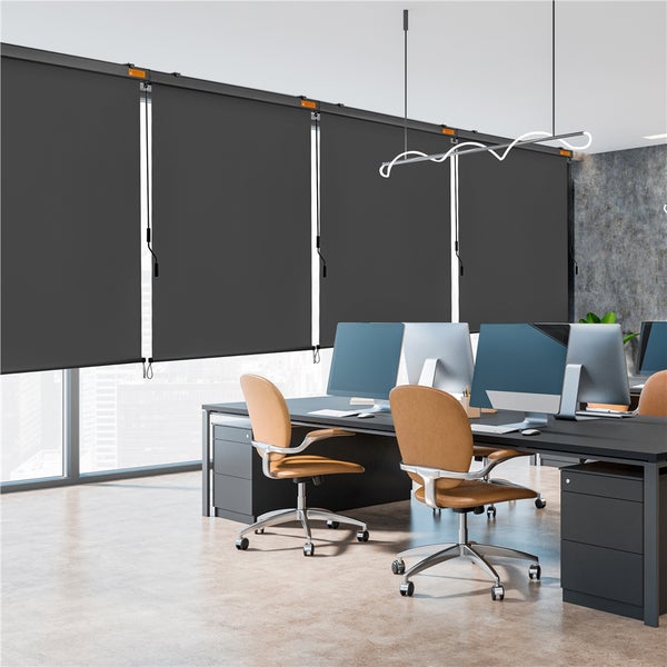 Modernes Büro mit grauen Rollos zur Verdunkelung vor den Fenstern.