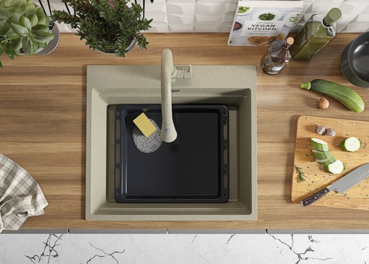 Küchenspüle mit Spültischarmatur, Spülschwamm und Backblech im Spülbecken