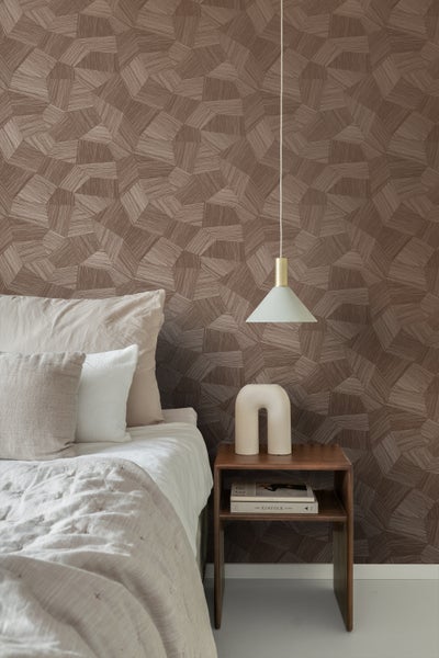 Schlafzimmer mit geometrischer Tapete, Nachttisch und Pendelleuchte