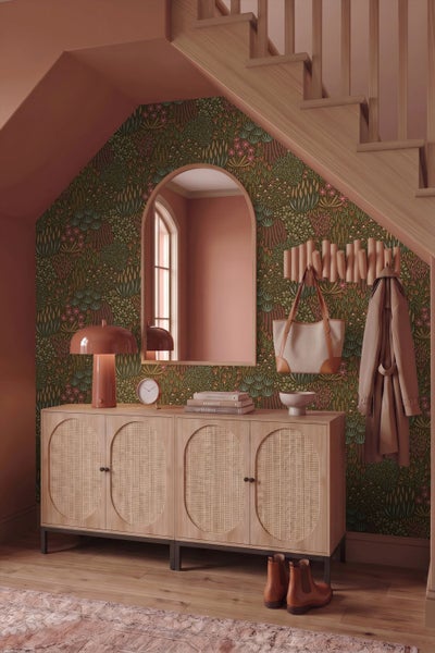 Botanische Vliestapete mit Blumenmuster, Wandspiegel, Marmortisch mit dekorativen Vasen und Kerzenständer.