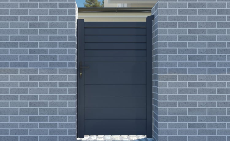 Modernes Gartentor in Anthrazit mit horizontalen Lamellen aus Aluminium, eingebaut zwischen zwei grauen Ziegelwänden mit schwarzer Klinke.